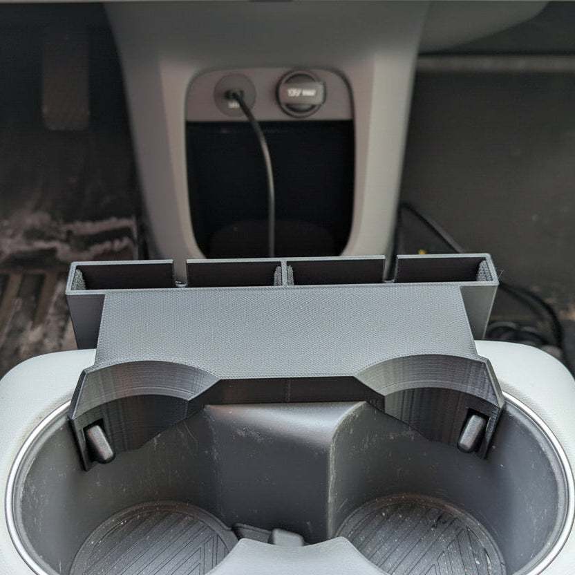 Car cup holder with a smartphone displaying the time and date.