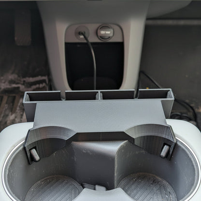 Car cup holder with a smartphone displaying the time and date.